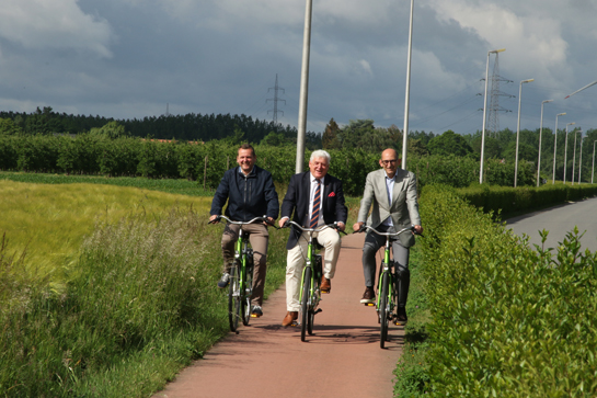 Gedeputeerde Lambrechts, burgemeester Penxten en schepen Vroonen testen zelf het fietspad aan de Langveldstraat